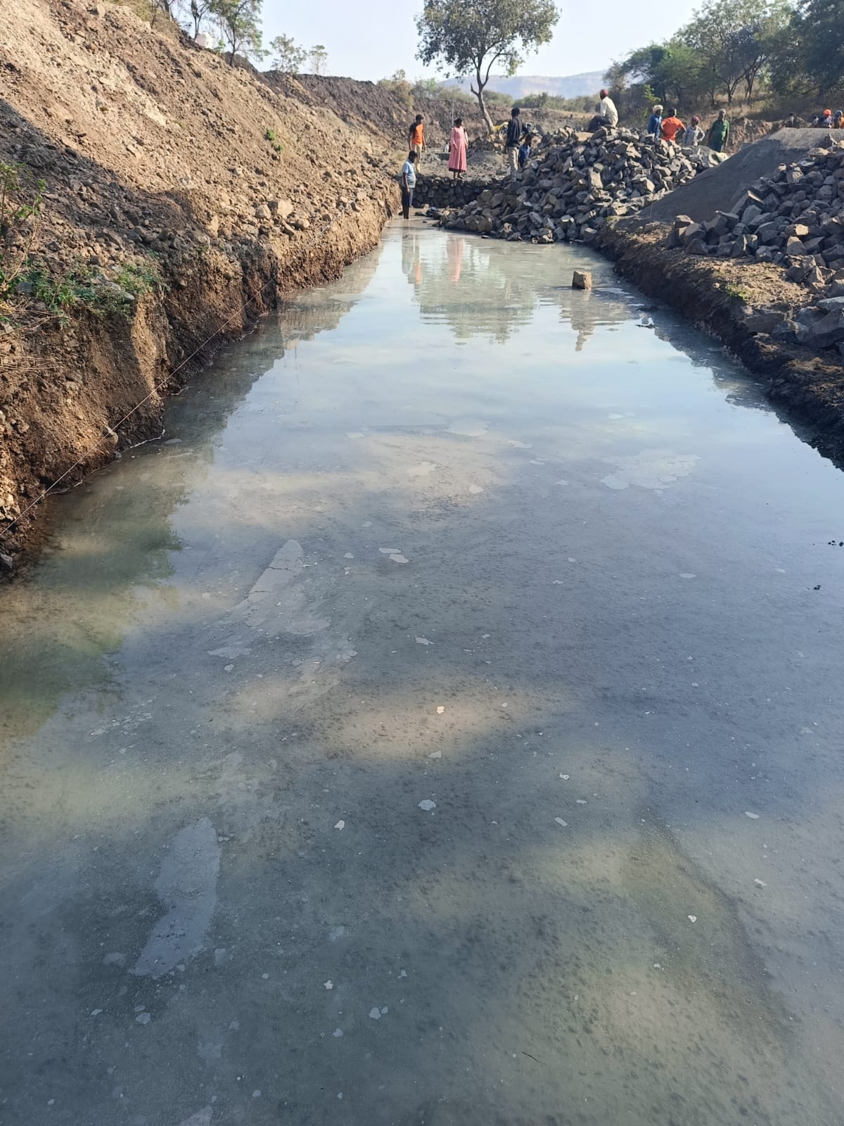 Canal earthwork with stone pitching and water flow