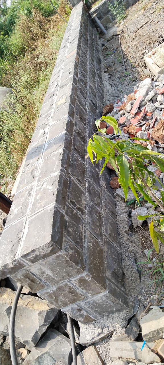Dressed basalt coursed retaining wall with cement coping