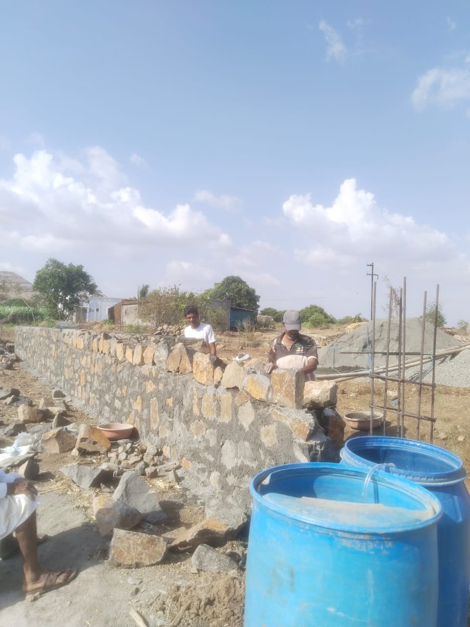 Skilled masons laying a stone compound wall