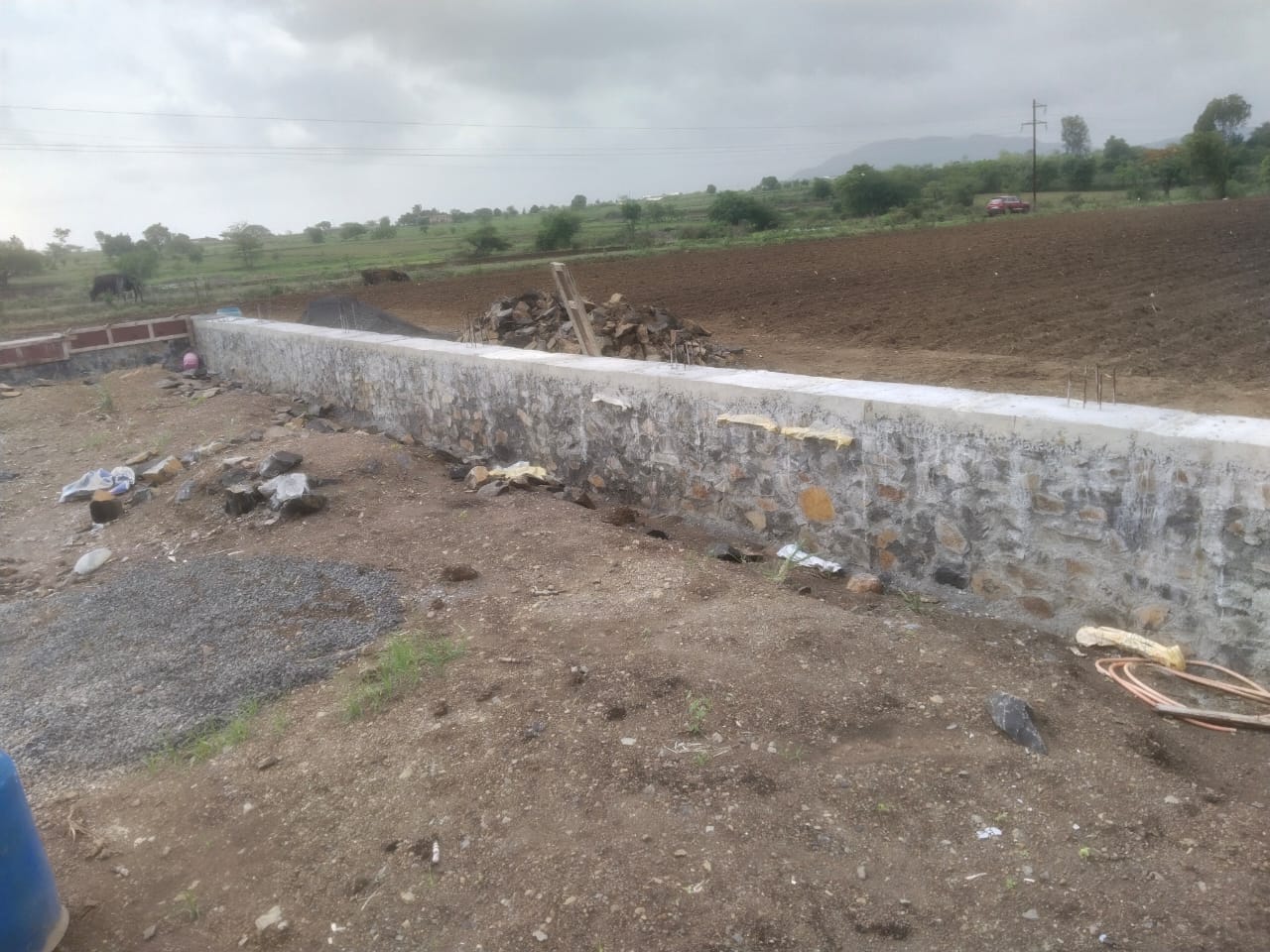 Completed stone boundary wall bordering a ploughed field